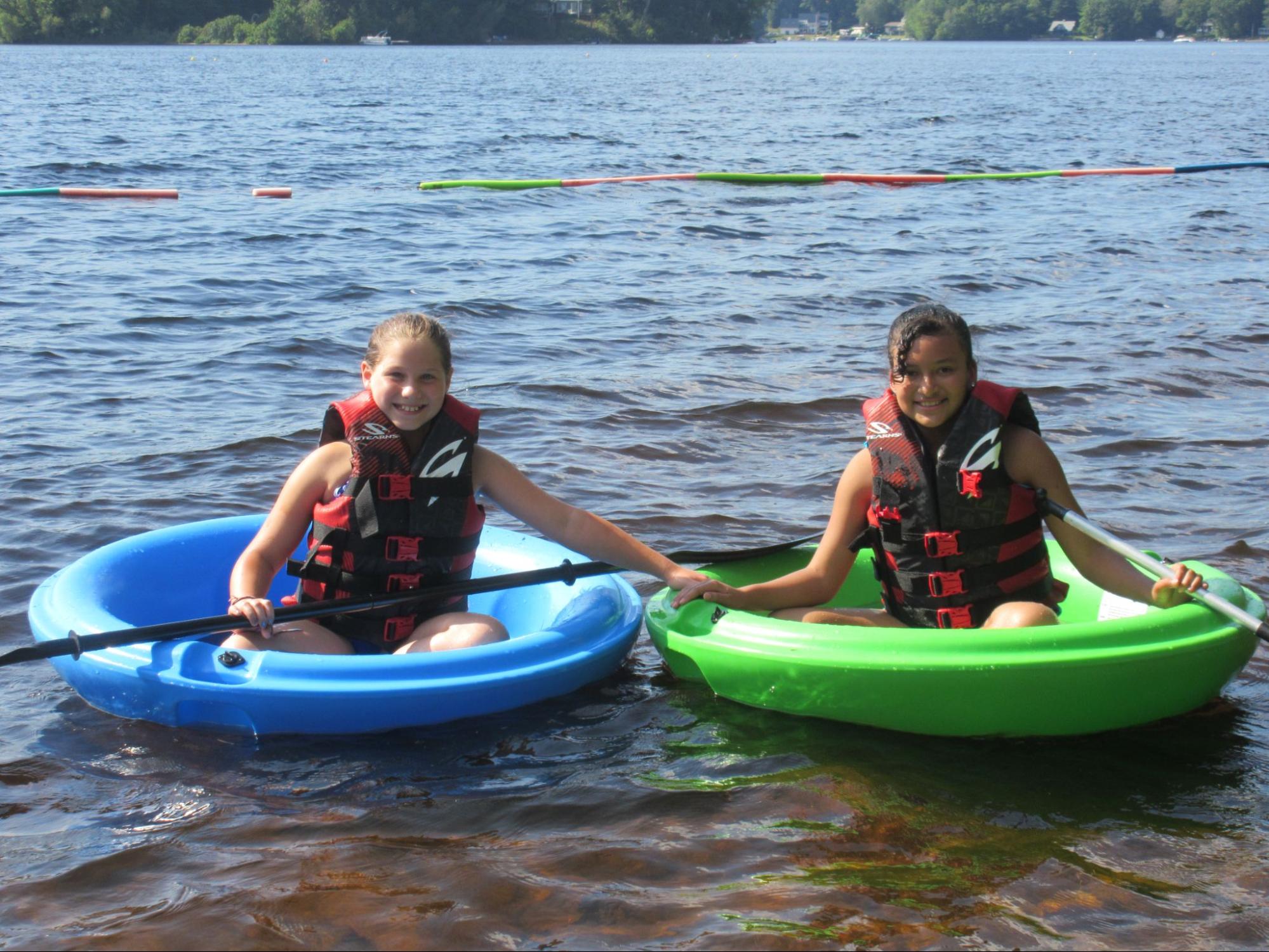 Two summer camp girls in boats at Camp Starfish