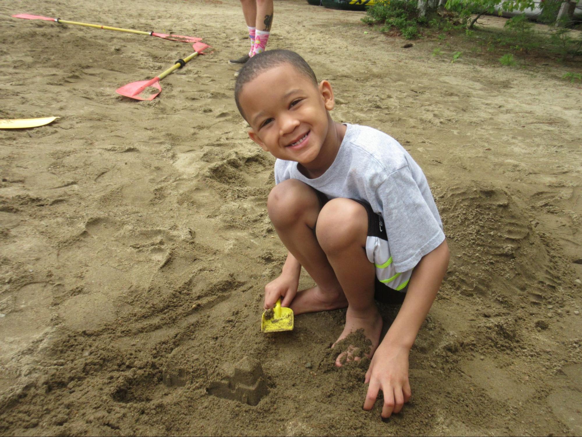 Camper boy playing in the sand