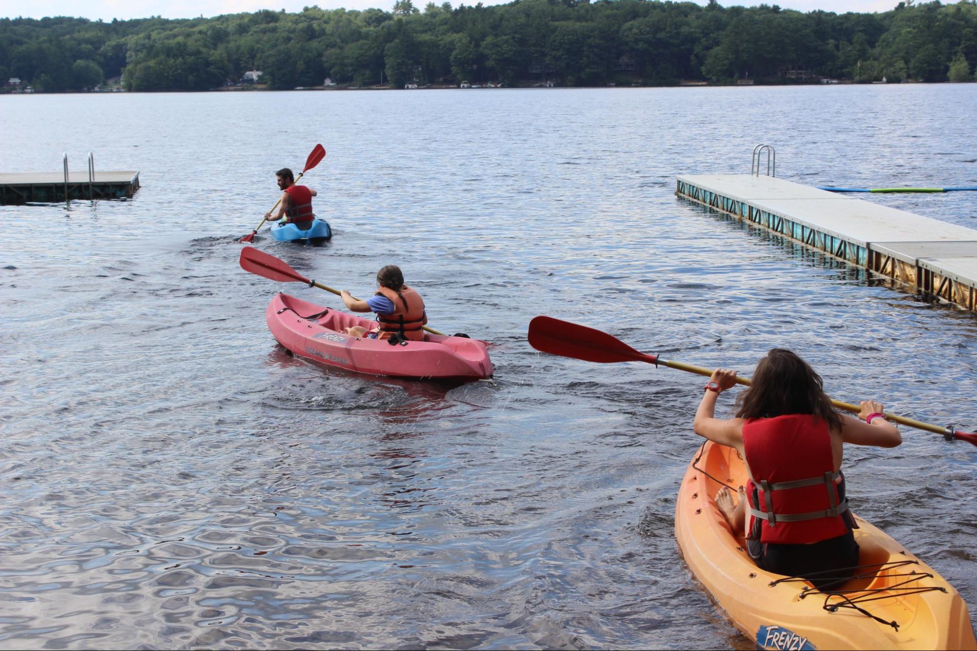 Three campers rowing on kayaks at Camp Starfish