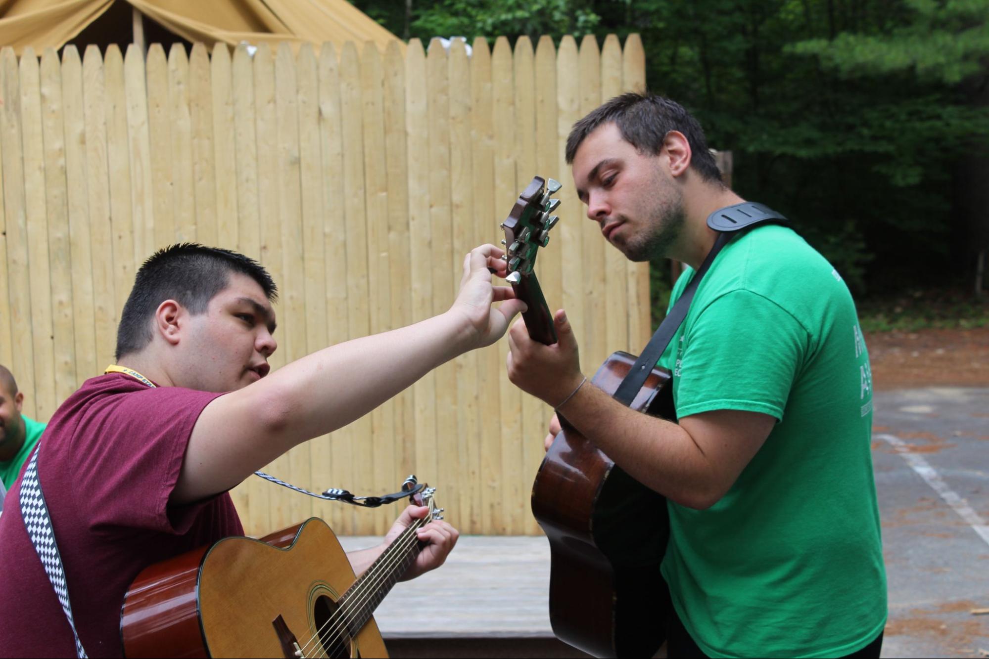 Camper and camp counselor playing guitar at Camp Starfish