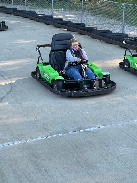 A camper at Teen Adventure Week riding a go cart