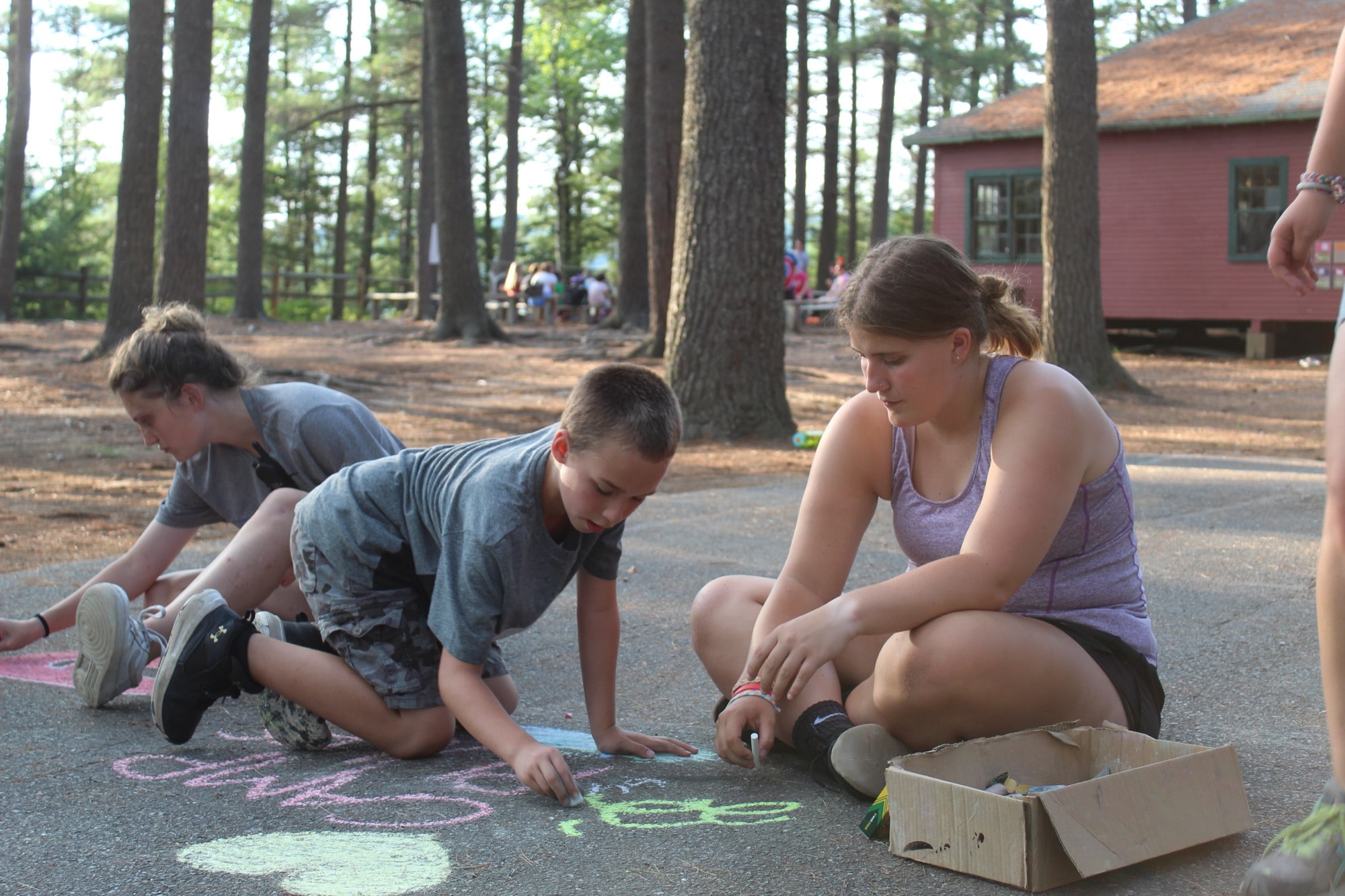 A child and camp counselor playing with chalk at Camp Starfish