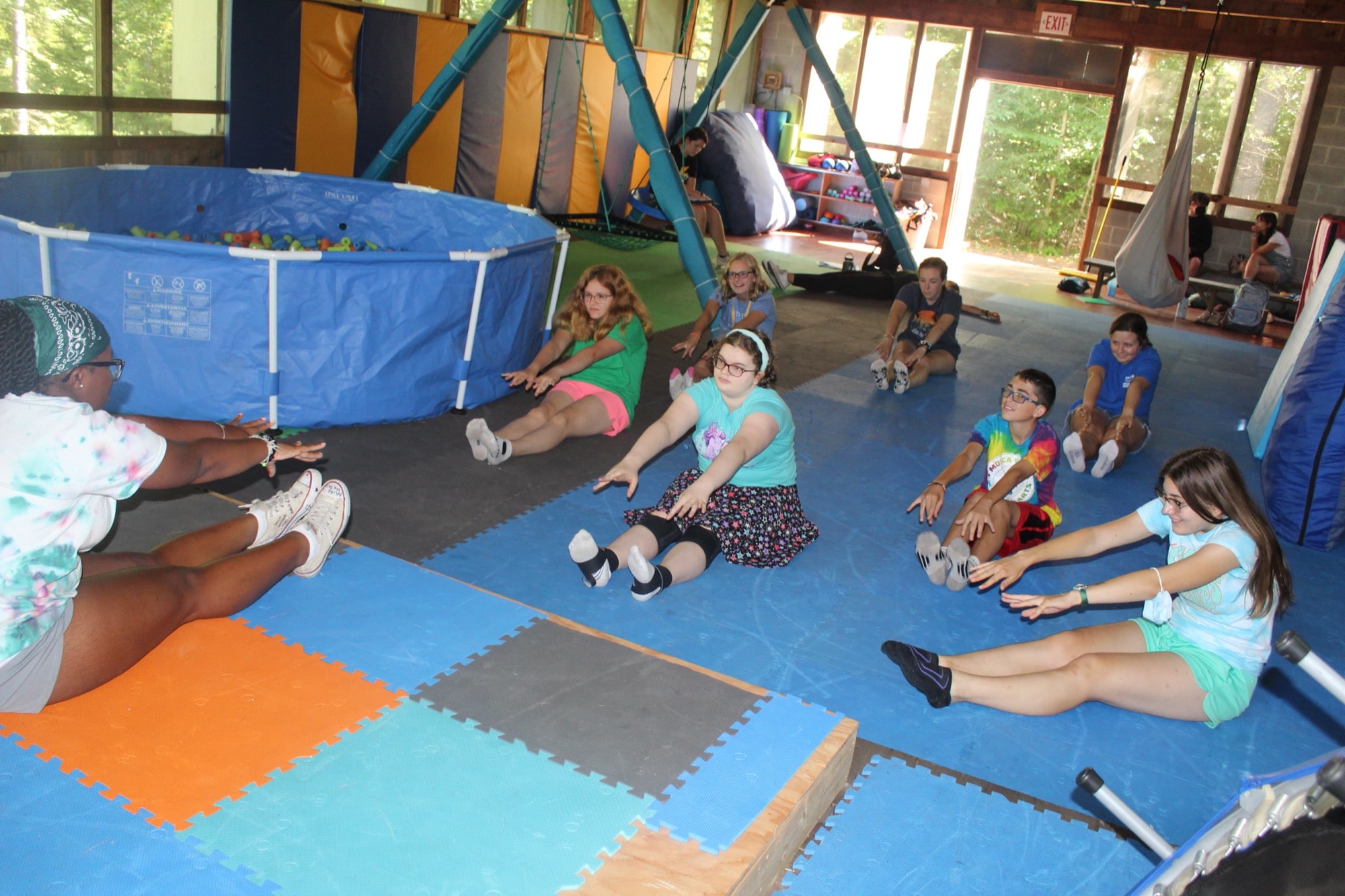 A group of campers being led by a counselor in a stretching class at Camp Starfish